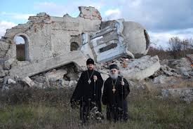 Kosovo Priests standing before destroyed church